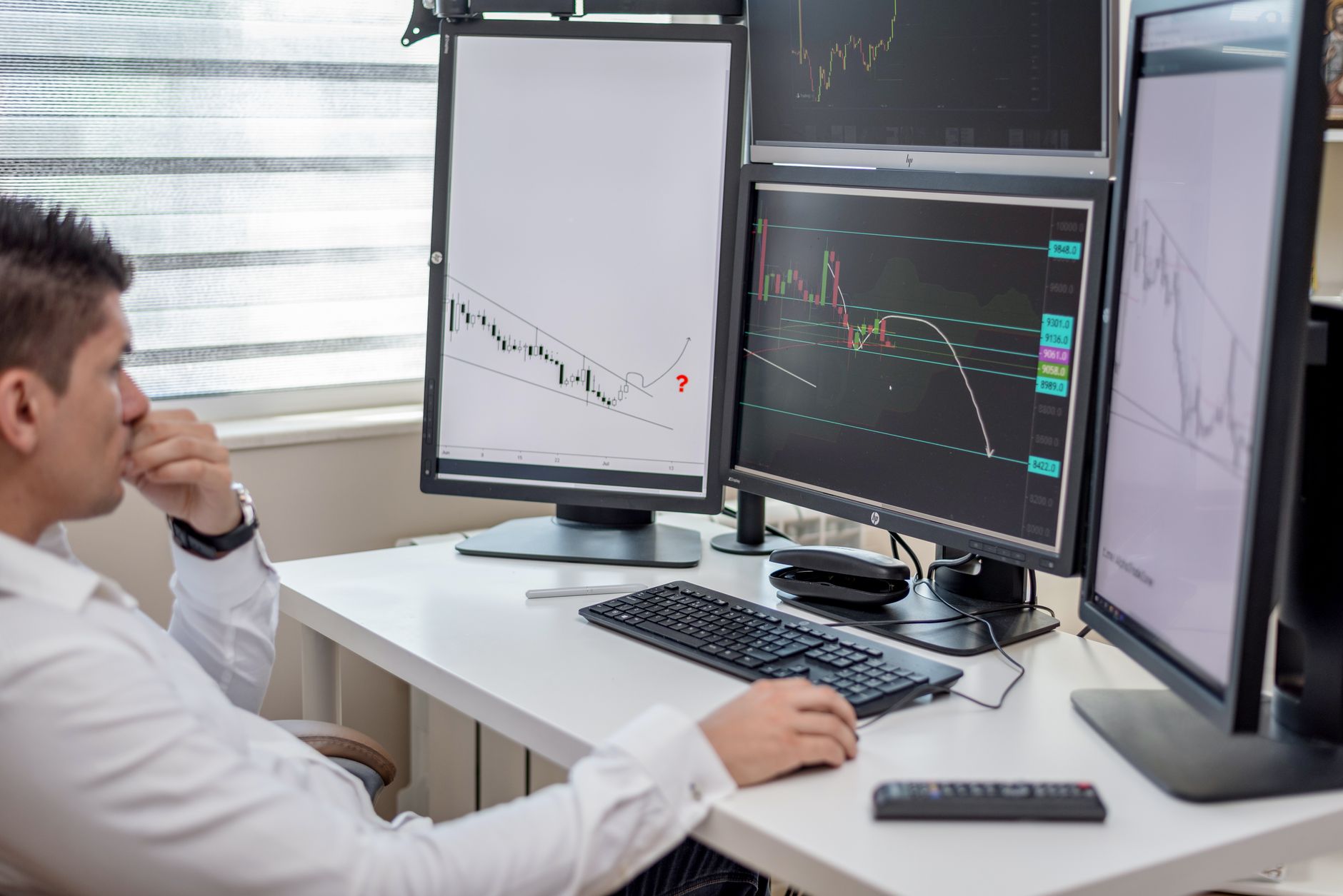 An analyst reviewing operational data across multiple monitors