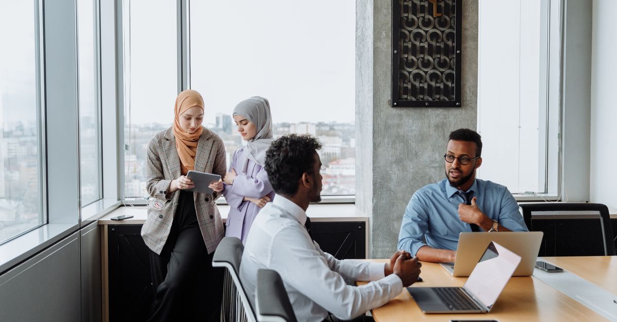 A diverse group of professionals engaged in a collaborative meeting in a modern office space.