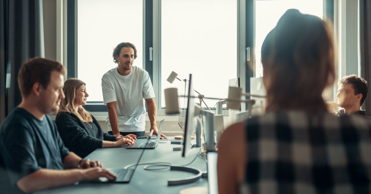 A diverse team engaged in discussion during a collaborative office meeting.